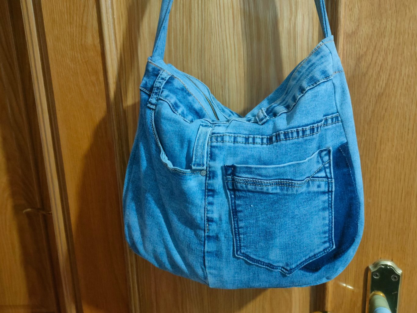 Bolso de tela vaquera azul con múltiples bolsillos delanteros. Bolso de tela vaquera azul con múltiples bolsillos delanteros.